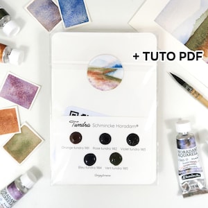 Peut inclure: Un ensemble de peinture aquarelle avec des tubes de peinture, des échantillons de couleurs et un pinceau. L'ensemble comprend un emballage blanc avec le texte "Tundra Schmincke Horadam" et les mots "+ TUTO PDF". La palette de couleurs comprend des nuances d'orange, de violet et de vert.