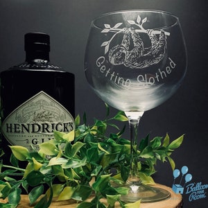 Peut inclure: Un verre à gin en verre transparent avec un motif gravé d'un paresseux suspendu à une branche. Le verre est gravé du texte "Getting Slothed".