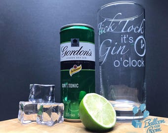 May include: A green can of Gordon's London Dry Gin with a lime wedge and ice cubes. The can says "Gin & Tonic" and has a Schweppes logo. A clear glass with the text "Tick Tock it's Gin o'clock" is in the background.