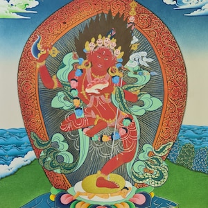 May include: A colorful painting of a red deity with multiple heads and arms, standing on a lotus flower. The deity is surrounded by a red and gold halo and is holding a white object in their hands. The painting is set against a blue sky with clouds and a green landscape.