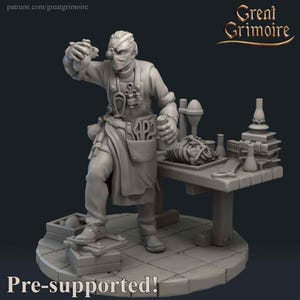 May include: A gray 3D printed miniature of a figure wearing a mask and holding a vial. The figure is standing at a table with a variety of tools and supplies. The miniature is pre-supported.