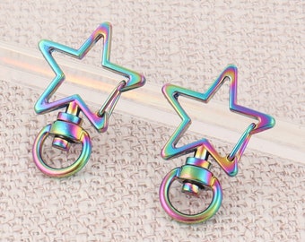 May include: Two iridescent star-shaped keychains with a swivel clasp. The keychains are made of metal and have a rainbow finish.