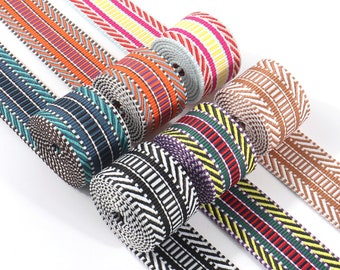 May include: Assortment of colorful woven ribbon with geometric patterns. The ribbons are rolled up and arranged in a circular pattern. The colors include red, orange, yellow, green, blue, purple, brown, and black.