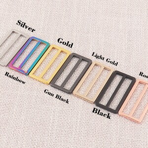 Puede incluir: Un juego de ocho hebillas deslizantes de metal en varios colores, incluyendo plata, arco&iacute;ris, oro, oro claro, negro mate, negro y oro rosa.