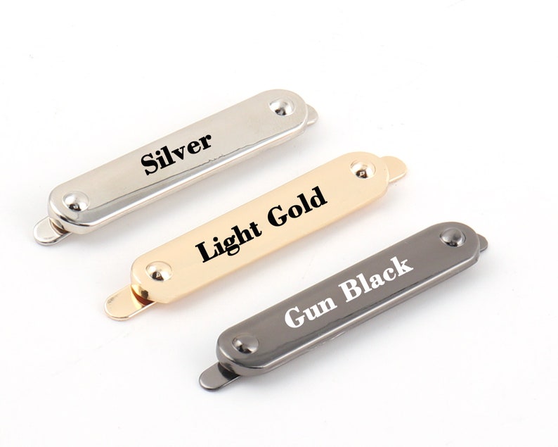 May include: Three metal rectangular clasps in silver, light gold, and gun black finishes. Each clasp has a rounded end and a small raised dot on the top. The clasps are labeled "Silver", "Light Gold", and "Gun Black".