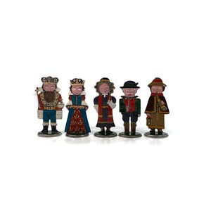 Op de afbeelding: Set van zes handgeschilderde tinnen figuren die een koning, een koningin, een vrouw in een blauw-rode jurk, een man in een groen-rood pak en twee mensen in bruin-rode outfits voorstellen. De figuren staan allemaal op een witte achtergrond.