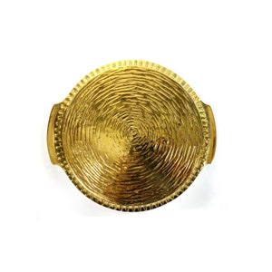 May include: A round, gold-colored metal tray with a textured surface and two handles. The tray has a circular design in the center.