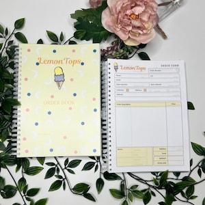 May include: A spiral-bound order book with a pale yellow cover featuring a small ice cream cone graphic, blue dots, and pink circles, alongside the text Lemon Tops ORDER BOOK. The open page displays an order form with fields for customer details.