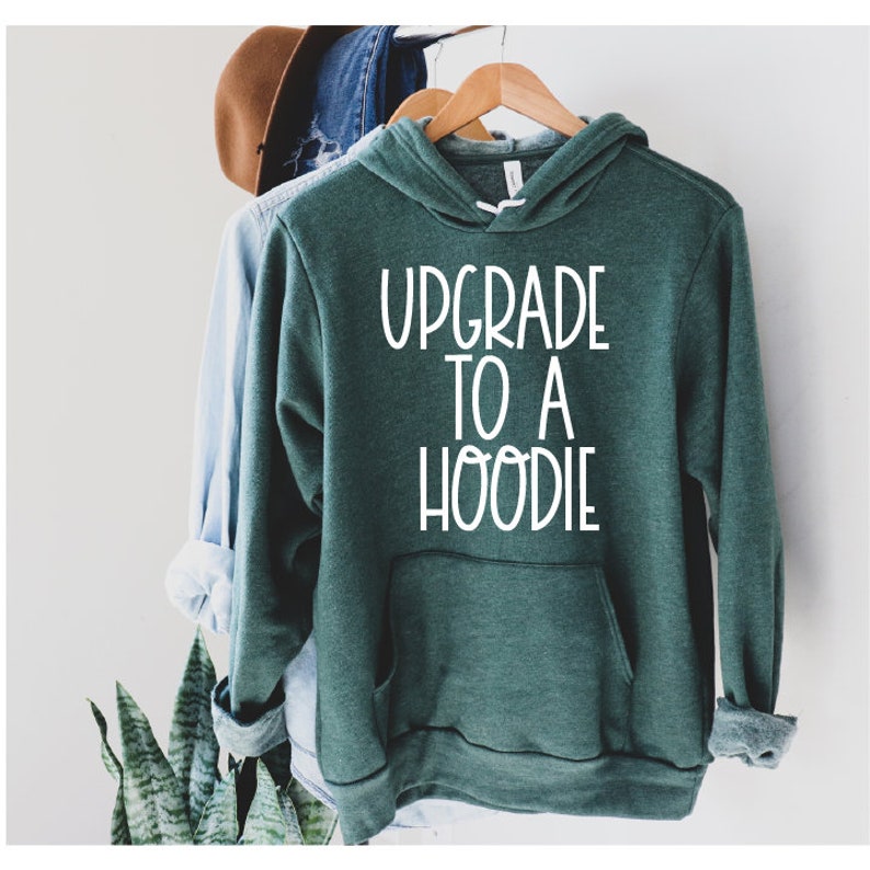 Pu&ograve; includere: Una felpa con cappuccio verde scuro con una grafica bianca che dice "Upgrade to a Hoodie".