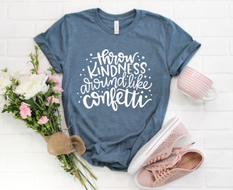May include: A blue t-shirt with the text "Throw Kindness Around Like Confetti" in white lettering.