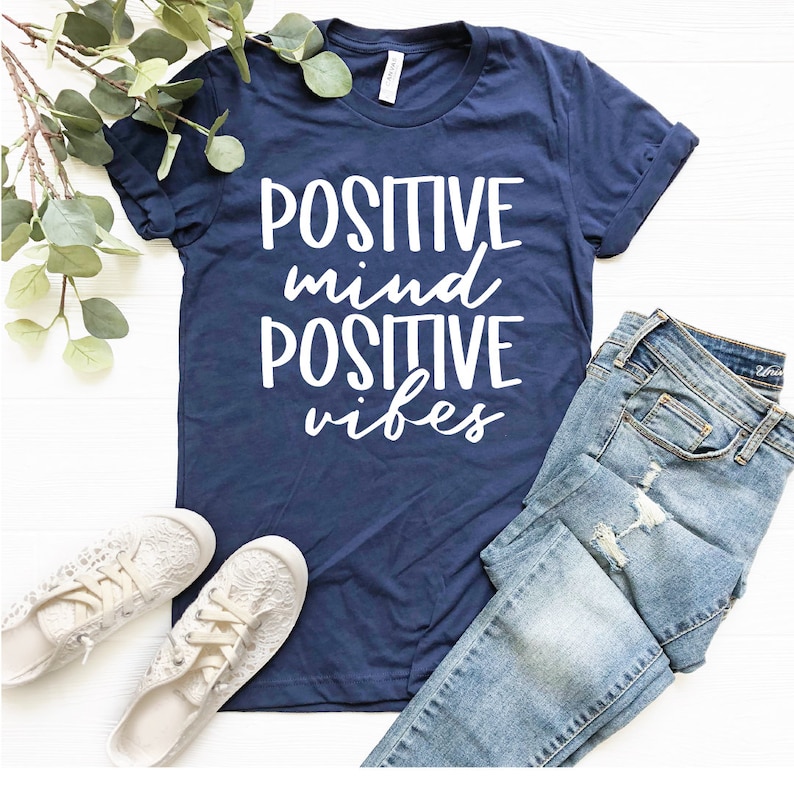 May include: A navy blue t-shirt with white text that reads "POSITIVE mind POSITIVE vibes".