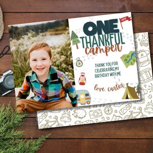 May include: A birthday invitation card with a photo of a young boy in a plaid shirt. The card has a blue and green camping theme with the text "ONE THANKFUL Camper" and "love, carten".