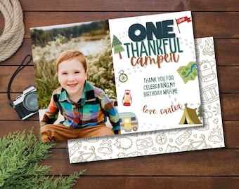 May include: A birthday invitation card featuring a photo of a young boy wearing a checked shirt. The card has a blue and green camping theme with the text "ONE THANKFUL Camper" and "love, carten".