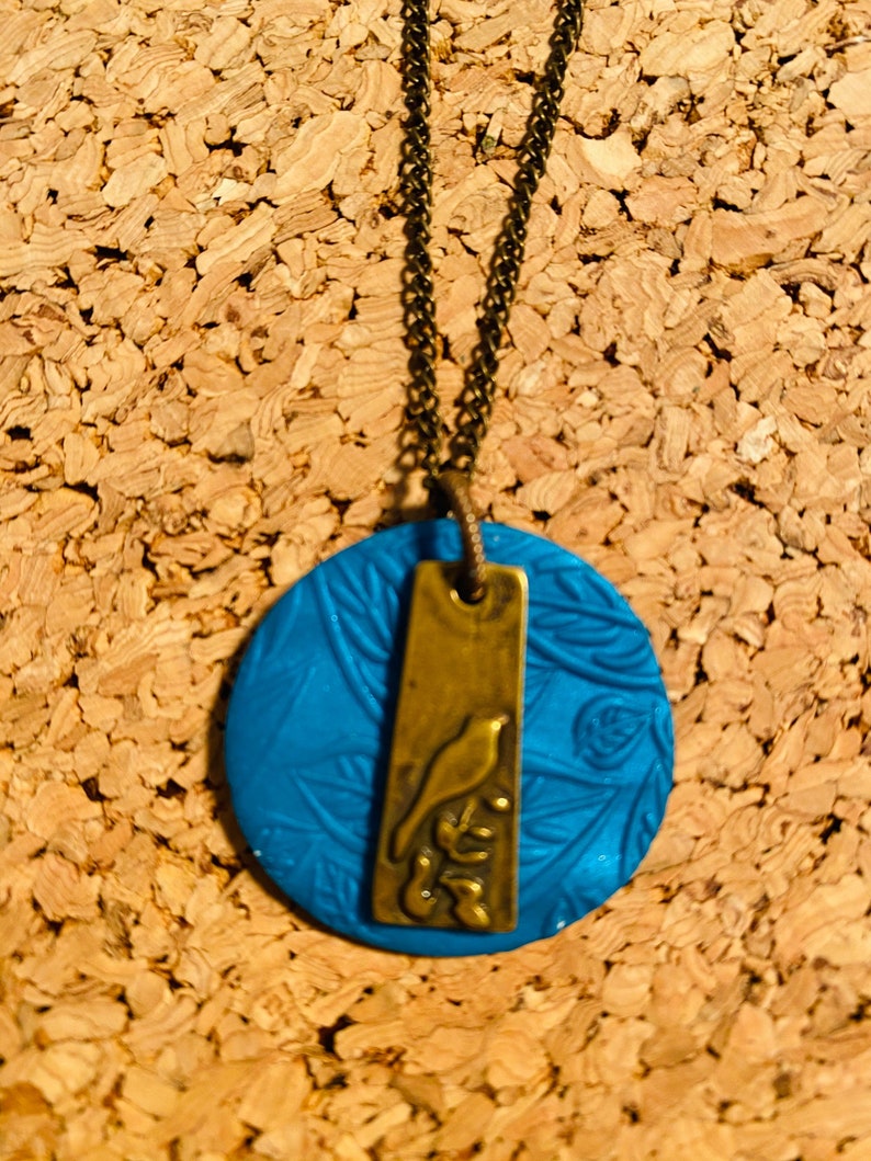 Stamped clay pendant with brass bird etched charm
