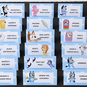 Pode incluir: Um conjunto de vinte e uma cartões de mesa retangulares azul-claros com vários personagens de desenhos animados e etiquetas de texto, incluindo Mackenzie's Mac and Cheese, Coco's Fruit Punch, Stripe's Sweet Tea, Lucky's Lemonade, Feather Wands, Granny Glasses, Pom Pom's Pasta Salad, Who Wants Cupcakes, Rita's Beans, Bluey Birthday Cake, Indy's Veggies, Chloe's Cheese Balls, Rusty's Rations, Fruit Bat Fruit, Chippies, Snicker's Sausage Rolls, Cheese and Crackers e Sandwich Shoppe.