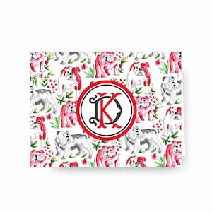 May include: White notecard with a red, white, and black monogram of the letter "K" surrounded by a red circle. The background is a repeating pattern of white and red bulldogs with green leaves and red flowers.