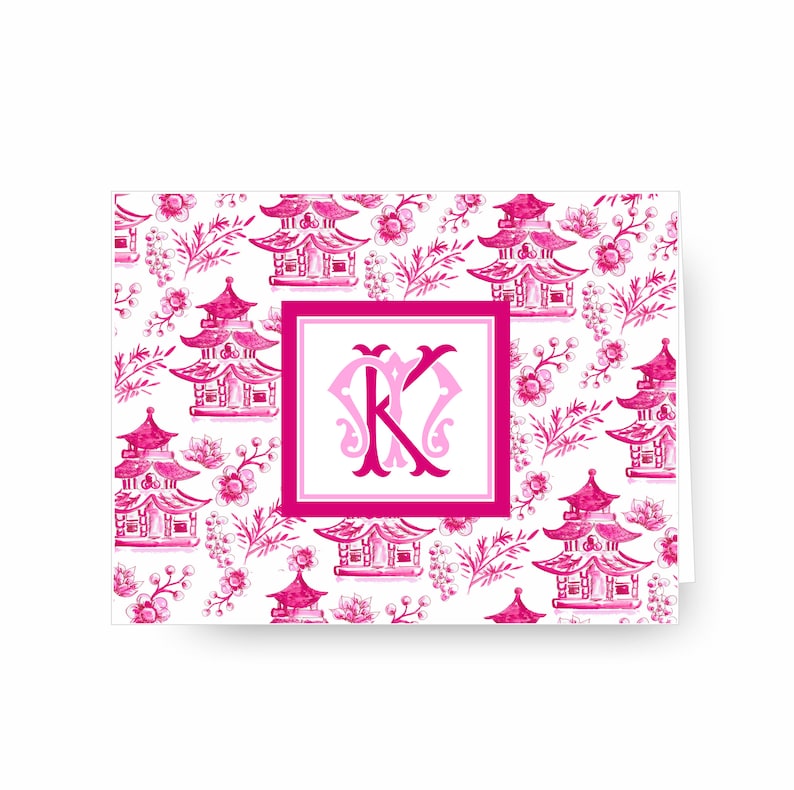 May include: Pink and white stationery card with a repeating pattern of pink pagodas and floral designs. The card features a large pink monogram "K" in the centre.