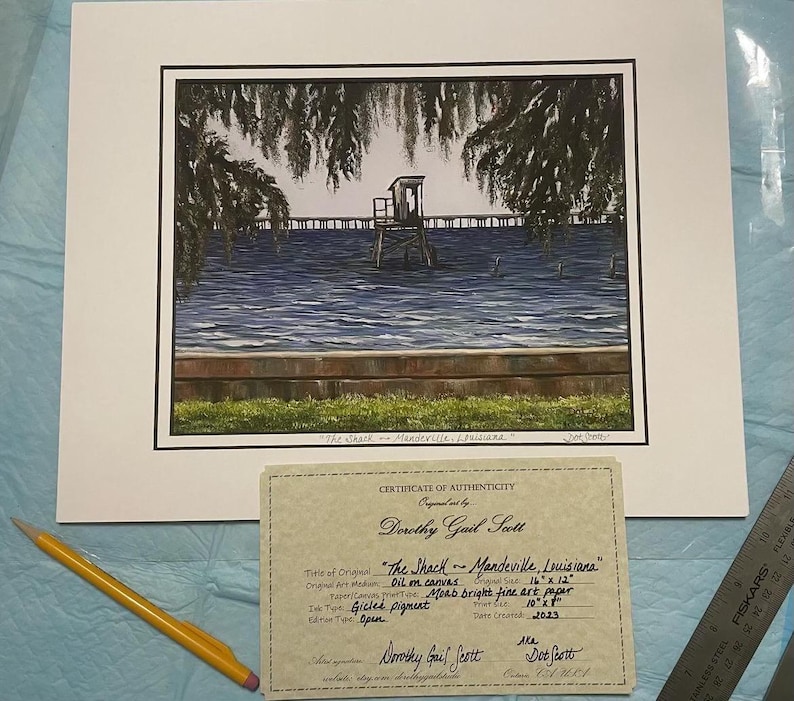 Pu&ograve; includere: Un certificato di autenticit&agrave; per un dipinto intitolato "The Shack - Mandeville, Louisiana" di Dorothy Gail Scott. Il dipinto &egrave; una stampa gicl&eacute;e su carta fine art Moab brillante, che misura 25,4 cm x 30,5 cm.