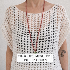 Puede incluir: Top de malla de crochet color crema con cuello ancho y mangas cortas. El top tiene un diseño abierto y aireado. Un collar de cuentas rojas con un colgante verde cuelga frente al top. Se muestra el texto "CROCHET MESH TOP PDF PATTERN".