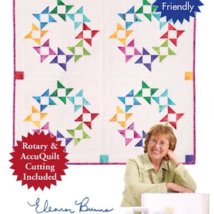 May include: A white quilt with four colorful star-shaped wreath designs. The quilt is labeled "Circle of Friends" and "Layer Cake Friendly." The image also includes a rotary and AccuQuilt cutting machine. The text "Quilt in a Day" is visible.