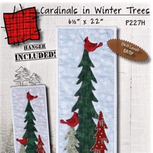 May include: A winter-themed wall hanging featuring appliqued trees and red cardinals. The design includes a large green tree, a smaller red tree, and a light blue background with snowflakes. The dimensions are 6.5 inches by 22 inches.
