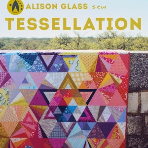 May include: A colorful quilt pattern with a geometric design of triangles in shades of pink, purple, blue, yellow, and orange. The quilt is 48 inches by 60 inches and is titled "Tessellation" by Nydia Kehnle + Alison Glass.