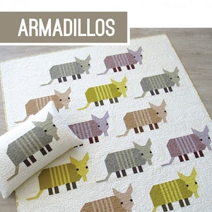May include: A quilt and pillow pattern featuring a patchwork design of armadillos in various colors, including brown, yellow, gray, and purple. The pattern is titled "Armadillos" and is by Elizabeth Hartman.
