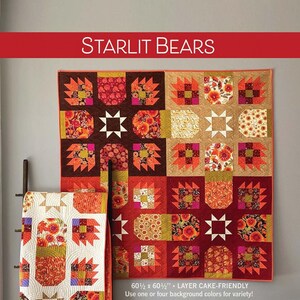 May include: A quilt pattern for a Starlit Bears quilt, featuring a patchwork design with orange, red, brown, and white fabrics. The quilt is 60 1/2 inches by 60 1/2 inches and is layer cake friendly. The pattern is by Robin Pickens.