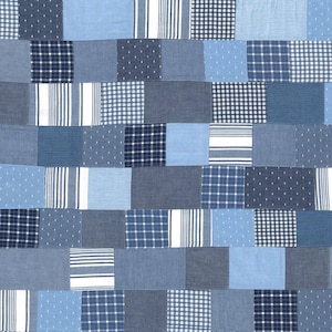 May include: A patchwork quilt made of various shades of blue denim fabric with different patterns, including stripes, polka dots, and plaid.