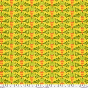 May include: A yellow fabric featuring a repeating pattern of orange carrots with green leafy tops. A white ruler is visible at the bottom edge, showing measurements in inches from 0 to 24, with the text FreeSpiritFabrics.com printed repeatedly.