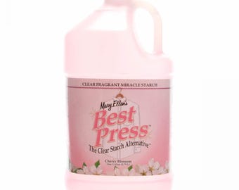May include: A pink plastic gallon jug of Mary Ellen's Best Press Clear Starch Alternative in Cherry Blossom scent. The label features a white shirt on a hanger and the text "The Clear Starch Alternative".