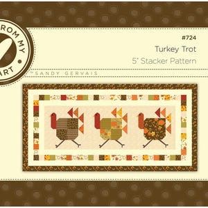 May include: A quilting pattern for a Thanksgiving turkey table runner. The pattern is called "Turkey Trot" and is a 5 inch Stacker pattern. The pattern features three turkeys in a row, each made of patchwork fabric in shades of brown, orange, yellow, and green.