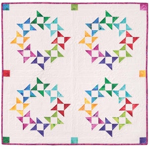 Może przedstawiać: Pikowana kołdra z białym tłem i czterema dużymi wzorami gwiazd. Każda gwiazda to pierścień kolorowych, zszywanych bloków w tęczowym gradiencie. Kołdra ma fioletową obwódkę i ozdobne przeszycia.