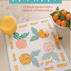 May include: A book titled "Make It Mini" with a white background and a quilt design featuring a green, yellow, and pink floral pattern. The book cover also includes the text "13 Small Quilts with a Splash of Embroidery" and "So Sweet".