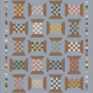 May include: A patchwork quilt with a light blue background and a repeating pattern of spool designs. Each spool features a different patterned fabric, including checks, florals, and solid colors in shades of brown, yellow, pink, and green. The quilt is bordered with a coordinating fabric.