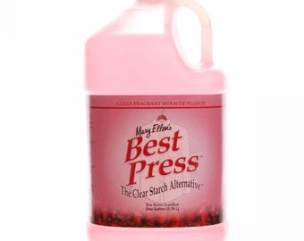 May include: A pink plastic gallon jug of Mary Ellen's Best Press Clear Starch Alternative in Tea Rose Garden scent. The label features a white shirt on a hanger and the text "The Clear Starch Alternative".