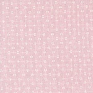 May include: A pink fabric with a white floral pattern. The pattern is a repeating design of small white flowers.