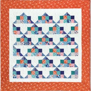 Pu&ograve; includere: Una trapunta con sfondo bianco e un motivo di quadrati blu, verdi, rosa e arancioni. La trapunta &egrave; bordata con un tessuto arancione pieno con un piccolo motivo floreale bianco.