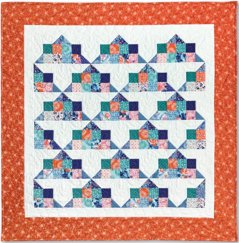 Pu&ograve; includere: Una trapunta con sfondo bianco e un motivo di quadrati blu, verdi, rosa e arancioni. La trapunta &egrave; bordata con un tessuto arancione pieno con un piccolo motivo floreale bianco.