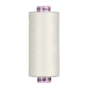 May include: A spool of white thread with the text "erFil Efina Col" and "an Cotton 60" printed on the spool. The thread is tightly wound and appears to be cotton.