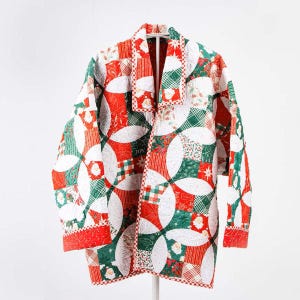 May include: A red and green quilted jacket with a white background. The jacket has a patchwork design with circles and a variety of Christmas-themed patterns. The jacket has a collar and a button closure.
