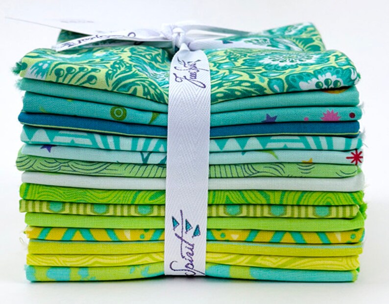 Op de afbeelding: Een stapel van 12 stofvierkanten in verschillende tinten groen en blauw met verschillende patronen. De stofvierkanten zijn met een wit lint aan elkaar gebonden. Het lint heeft de tekst "Sprout & Flourish" erop gedrukt.