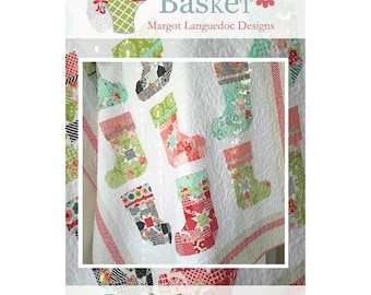 May include: A quilt pattern featuring a white background with colorful patchwork stockings. The title "Ready for Santa" is printed below the quilt. The text "The Pattern Basket" is printed at the top of the image.
