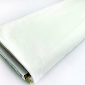 May include: A roll of white fabric, folded and ready to be used for sewing or crafting projects.
