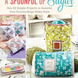 May include: A book titled "A Spoonful of Sugar" with a colorful illustration of a green and white fabric bag, a teal and white fabric bag, and a colorful patchwork fabric wallet. The book cover also features the text "Sew 20 Simple Projects to Sweeten Your Surroundings Zakka Style" and the author's name "LISA COX".