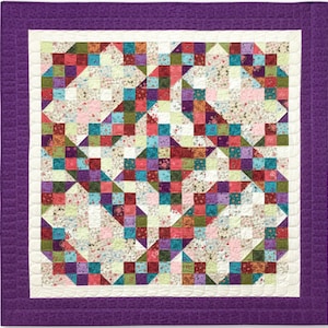 Pu&ograve; includere: Una trapunta viola e bianca con un design a patchwork che presenta vari motivi floreali in tonalit&agrave; di rosa, rosso, verde e blu.