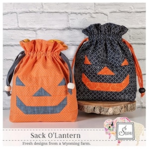 May include: Two Halloween-themed drawstring bags with a jack-o'-lantern face design. One bag is orange with white polka dots and the other is black with white circles. The bags are made of fabric and have a drawstring closure. The text "Sack O'Lantern" is printed below the bags.