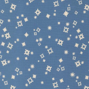 May include: A close-up of a blue fabric with a repeating pattern of white star-like shapes. The design includes various sizes and styles of stars, creating a scattered, celestial appearance. The fabric has a slightly textured surface.