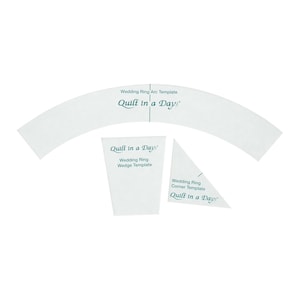 May include: Quilt in a Day templates for a wedding ring quilt. The set includes a white arc template, a white wedge template, and a white corner template. Each template has the text "Quilt in a Day" printed on it.