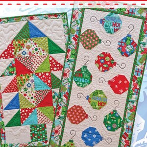 May include: A quilt pattern titled charming christmas table runners by Material Girlfriends featuring two designs: one with a geometric tree made of red, green, and blue patterned fabric, and another with hanging ornaments on a cream background.